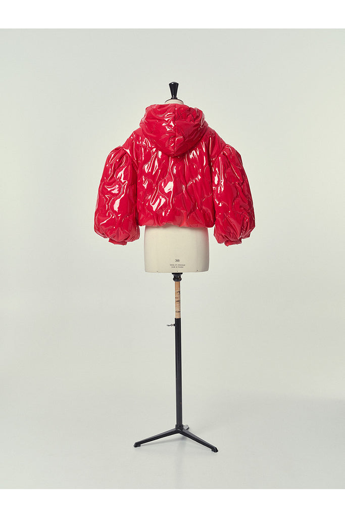 Composition: Out : 100% Polyurethane 5% Elastane 79% Polyester In: 100% Polyester Padding: 100% Polyester

Made in: Spain

Short jacket with hood and puffed balloon sleeves, made in shiny quilted red patent PU fabric. Fastens with press studs and pockets on the sides, with a fine concealed elasticated hem that adjusts to the body.