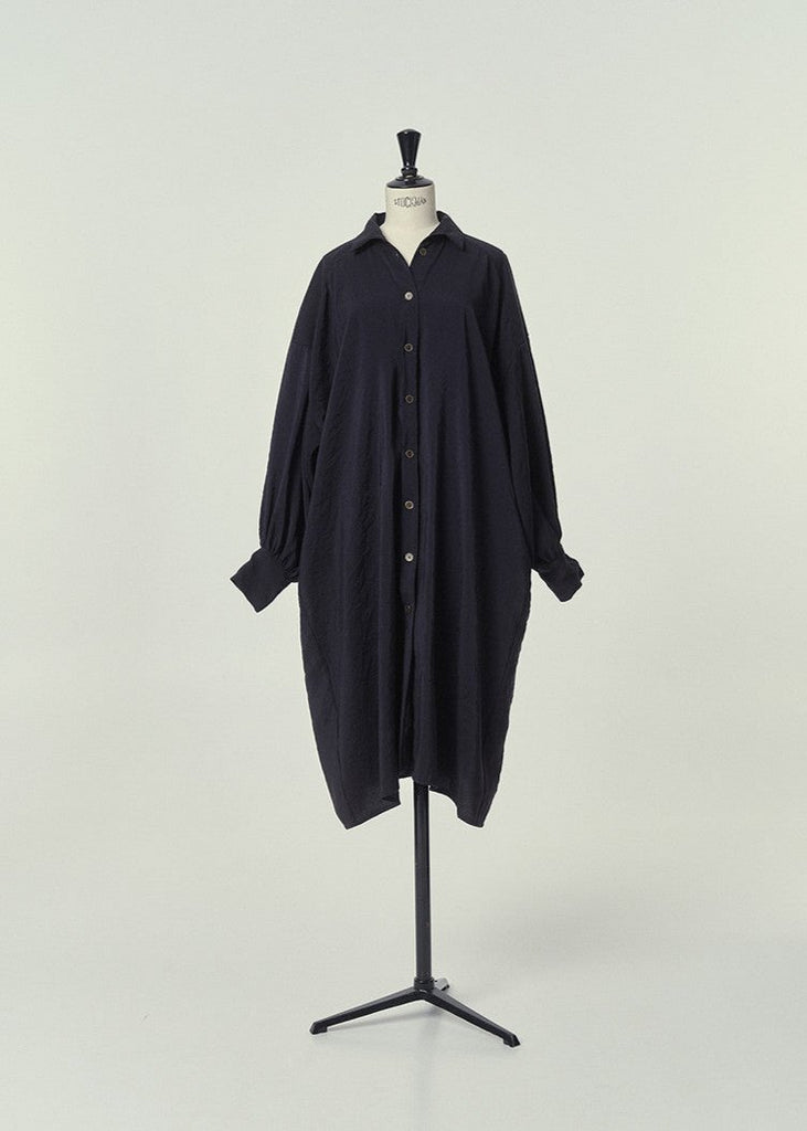 Composition: 84% Modal 6% Polyester

Made in: Spain

Midi length shirt dress with full functioning placket at the center front with old gold buttons, made in premium soft cupro fabric in black. Dropped shoulder seams and gathered cuff detailing to create volume sleeves. Side seam pockets.