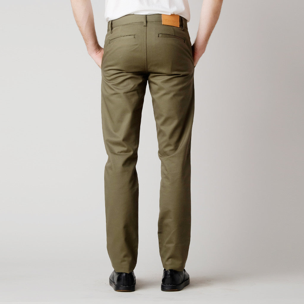 Back view of slim Jalapeno green chino pants made in USA by BDC. Our men's chinos are pants made in the USA of 100% cotton. They feature a slimming fit throughout the leg with side pockets and slit back pockets.

Customize the fit with complimentary hemming.

100% Cotton
Slim Fit
Zipper Fly
Made in USA
Colors: Sand, Black, Jalapeño Navy