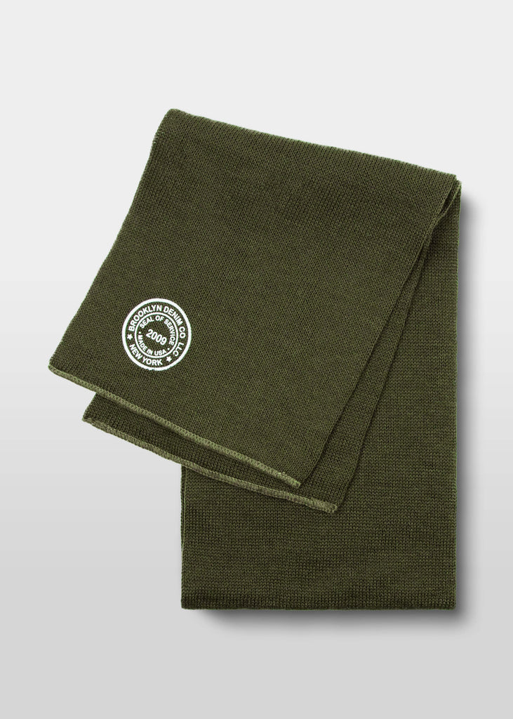 Made from 100% wool, this Brooklyn Denim Co. knit scarf has an updated vintage military deadstock vibe. This scarf features the Brooklyn Denim Co. seal logo, screen printed in white. Keep warm this winter in Brooklyn Denim Co merch! Available in black and olive.

100% wool

Screen printed seal logo
One size fits all
